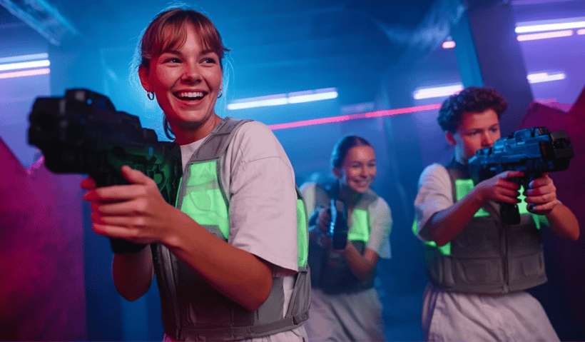 A group of young people playing laser tag and laughing