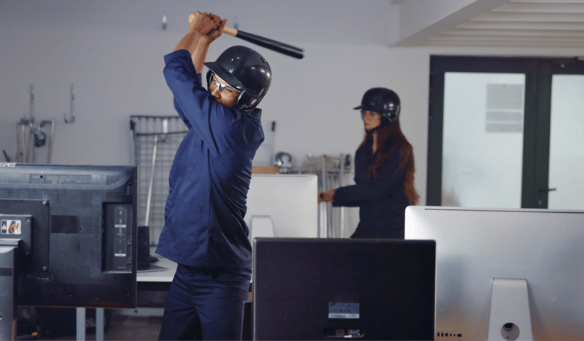 A man swinging a bat in a rage room