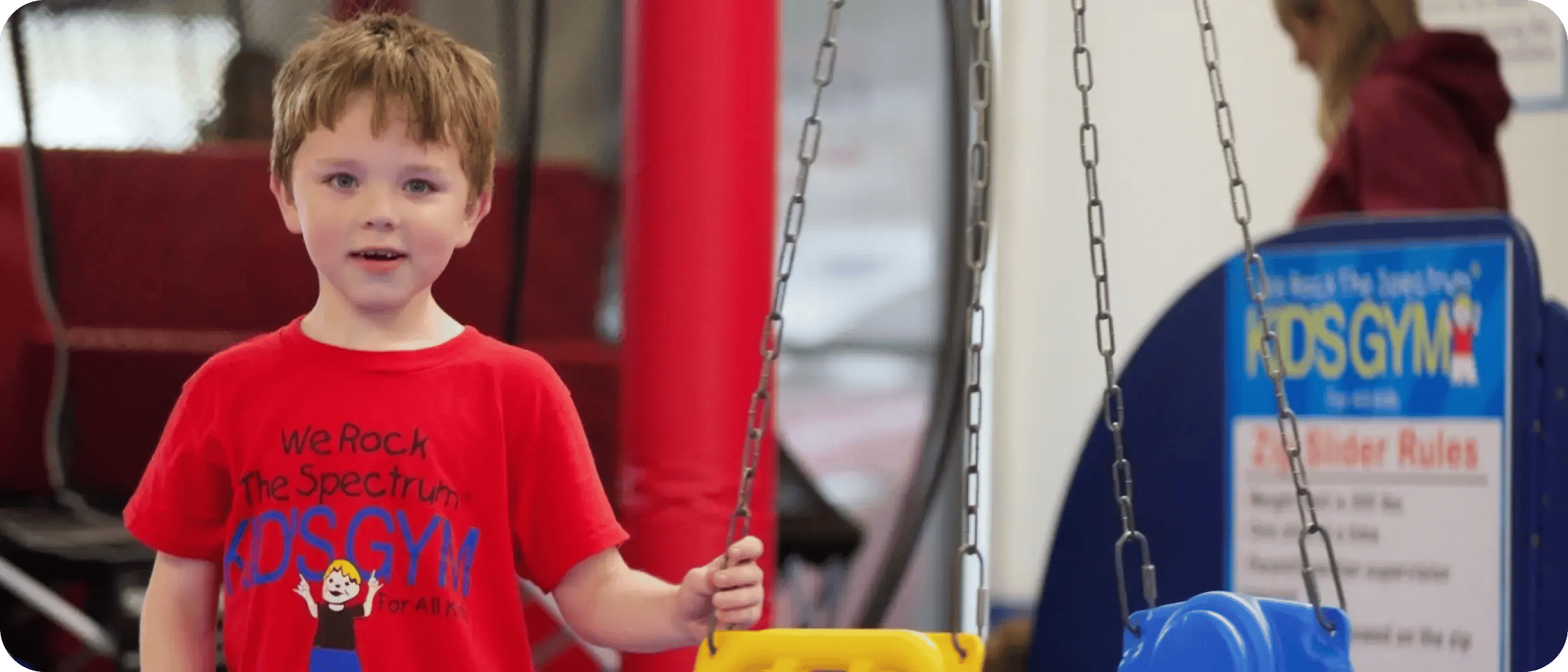 Child playing on a glider swing in the gym