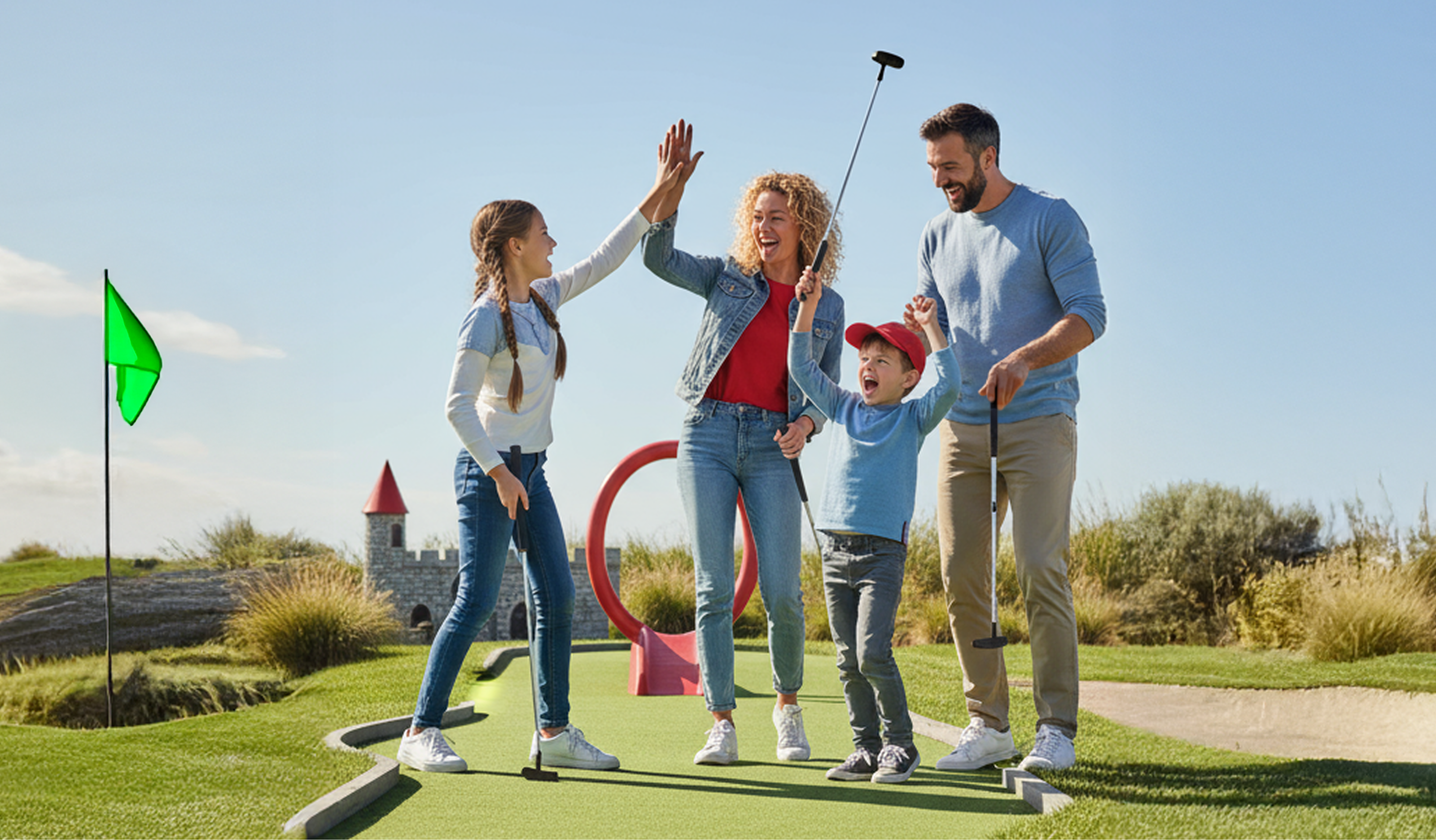 A family with young children celebrating on an outdoor mini gold course