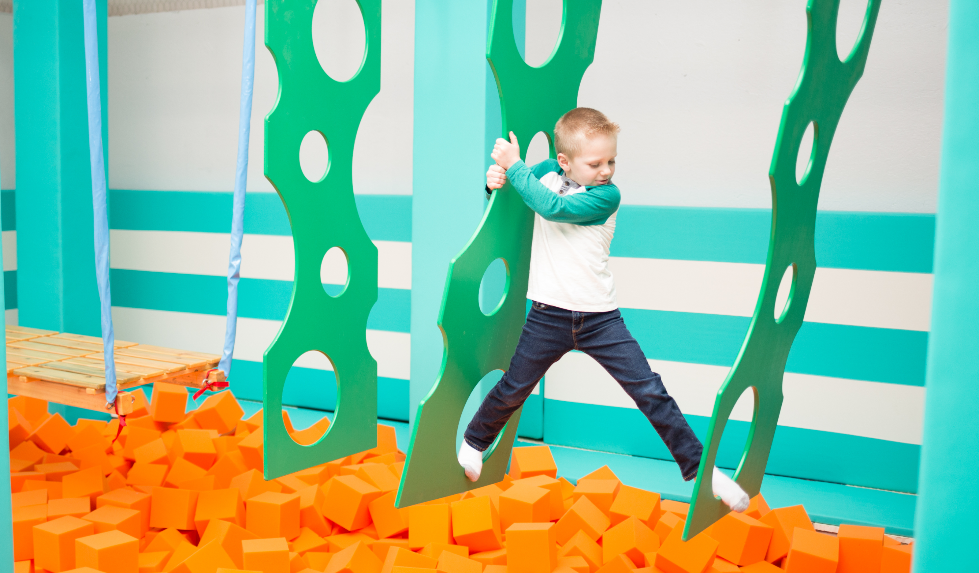 A young boy moving through an obstacle course at a ninja warrior gym
