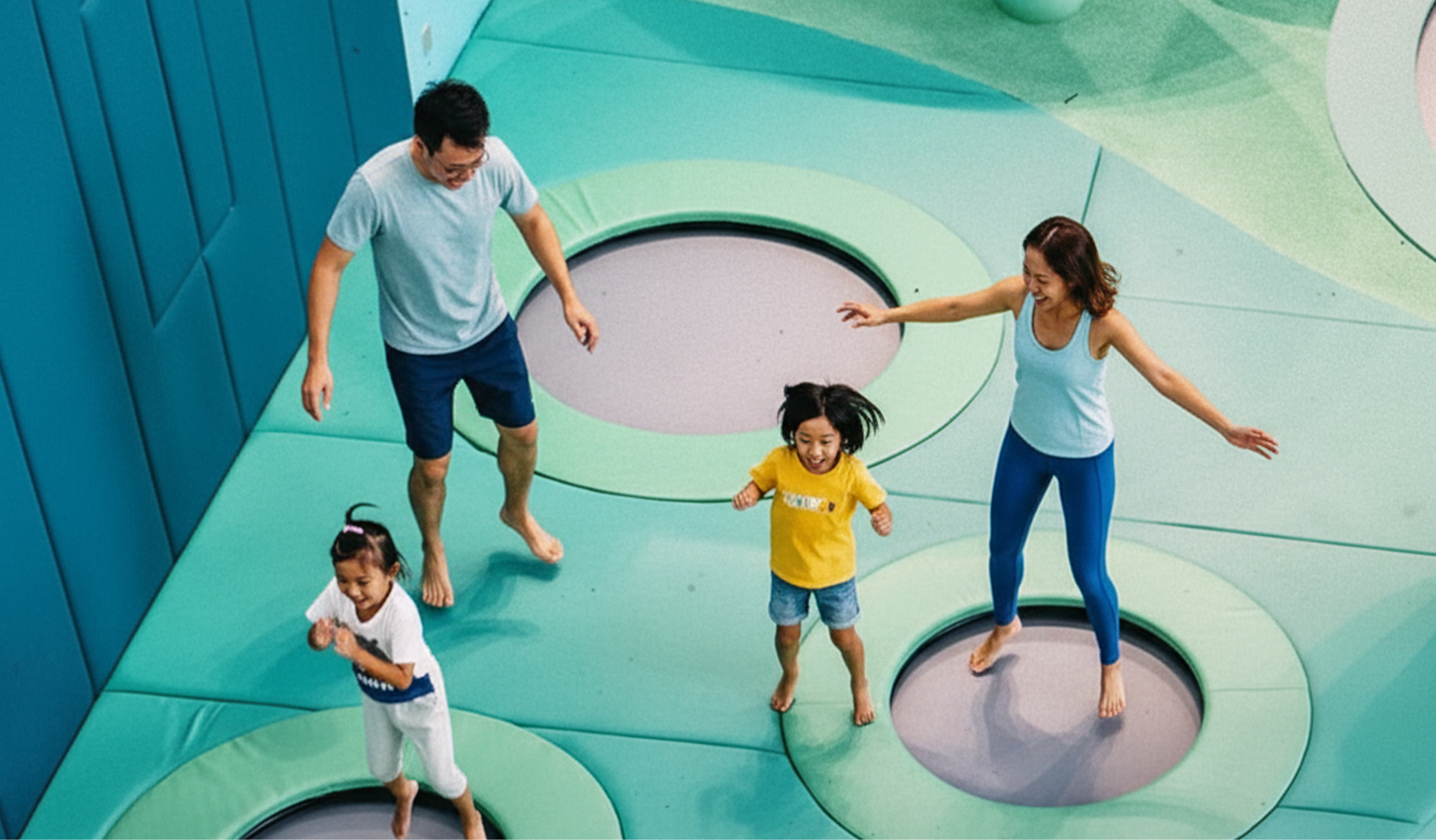 A family with young children bouncing on mini trampolines at a trampoline park